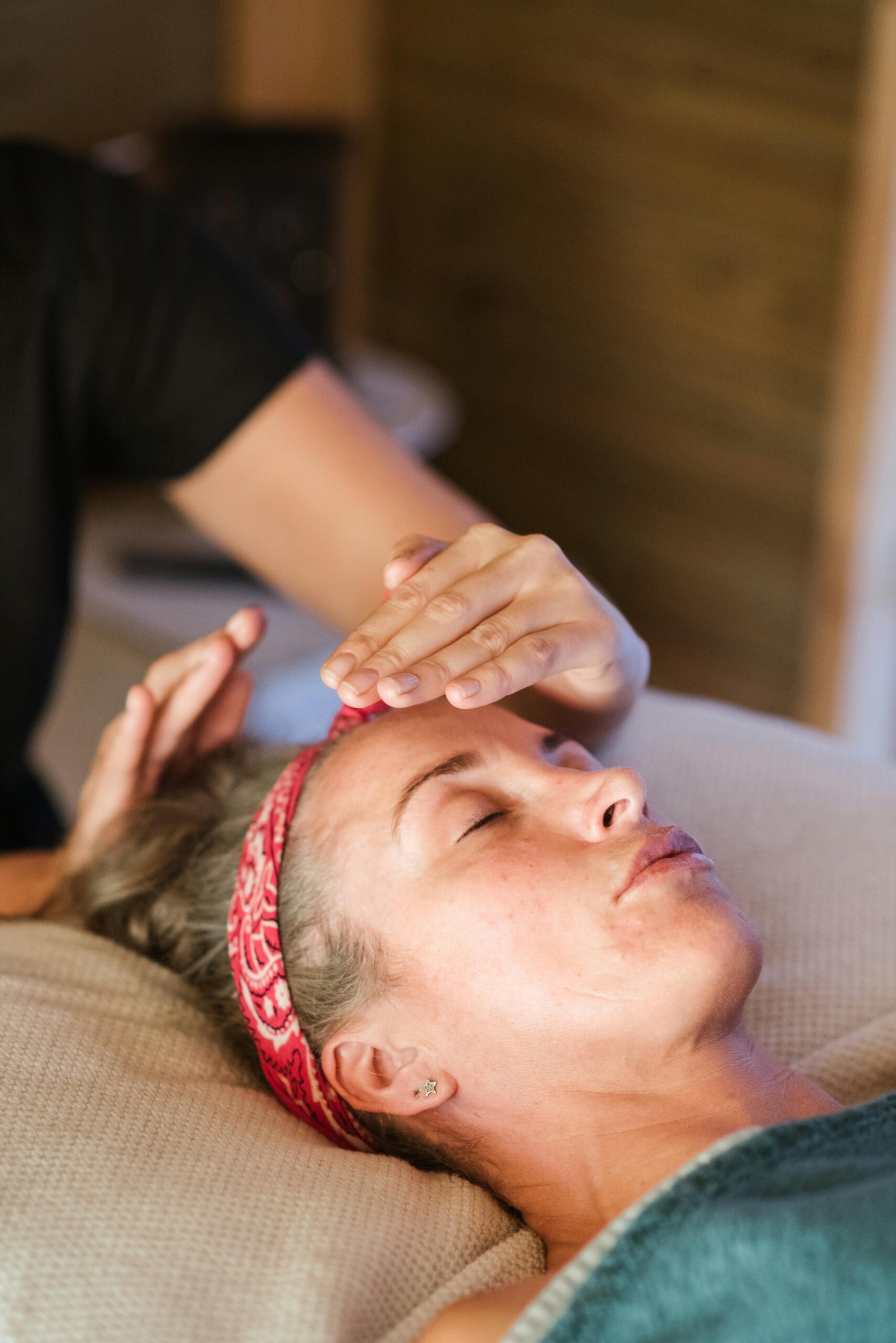 INICIO A woman enjoying a peaceful reiki session in a cozy spa setting for ultimate relaxation.